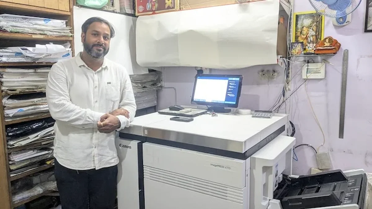 Canon imagePRESS V770 presinin önünde duran matbaa operatörü ve kontrol paneli
